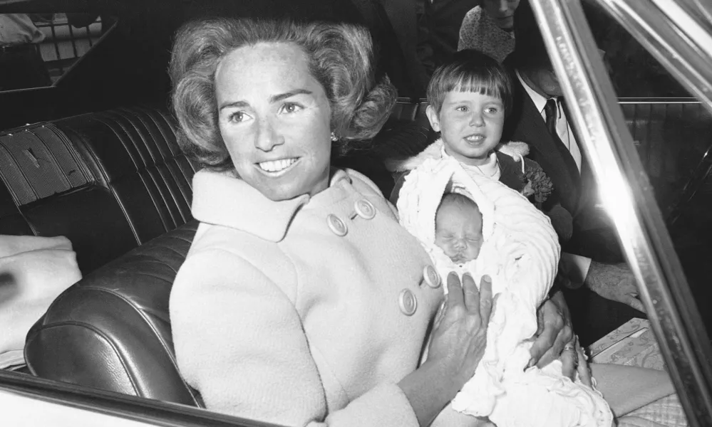 FILE - Ethel Kennedy holds her new son, Douglas Harriman Kennedy, with two-year-old Christopher Kennedy, right, as they leave Georgetown University in Washington, April 13, 1967, for home. (AP Photo/Henry Burroughs, File)