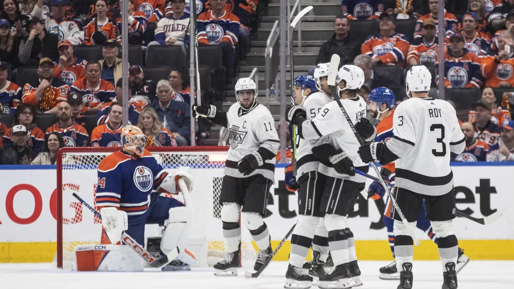 Los Angeles Kings' Anze Kopitar (11), Quinton Byfield (55), Adrian Kempe (9) and Matt Roy (3) celebrate a goal as Edmonton Oilers goalie Stuart Skinner (74) looks on during the second period of Game 1 in first round NHL Stanley Cup playoff hockey action in Edmonton, Alberta, Monday, April 22, 2024. (Jason Franson/The Canadian Press via AP)