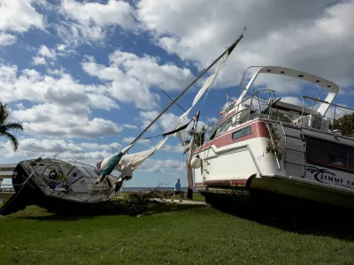 A man walks past boats resting in a public park after they were washed ashore when Hurricane Milton passed through the area, in Punta Gorda, Florida, U.S., October 10, 2024. REUTERS/Ricardo Arduengo