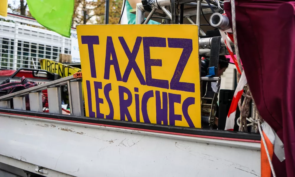 France, Paris, 2024/10/01. Inter-professional demonstration in Paris and throughout France for wages, public services and the repeal of pension reform. A sign reading tax the rich on a lorry. Photography by Myriam Tirler / Hans Lucas.France, Paris, 2024/10/01. Manifestation interprofessionelle Paris et dans toute la France pour les salaires, les services publics et l'abrogation de la reforme des retraites. Une pancarte ou est ecrit taxez les riches sur un camion. Photographie de Myriam Tirler / Hans Lucas.