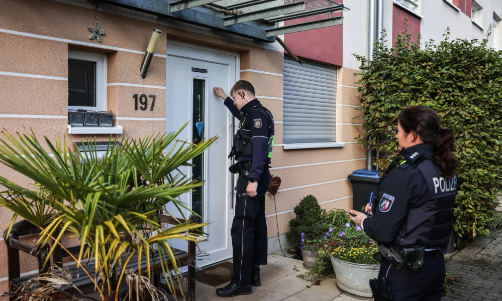 11 October 2024, North Rhine-Westphalia, Cologne: Police officers ring the doorbells of terraced houses in the Merheim district. A bomb from the Second World War is to be defused in Cologne on 11 October. Around 6,400 residents will have to leave their homes. According to the city, it is the most extensive evacuation of this kind in Cologne since 1945. Photo: Oliver Berg/dpa