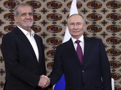 Russian President Vladimir Putin, right, and Iranian President Masoud Pezeshkian pose for a photo during their meeting on the sidelines of the International Forum "The Interconnection of Times and Civilizations – the basis of peace and development" dedicated to the 300th anniversary of the birth of the outstanding Turkmen poet and thinker Magtymguly Fragi in Ashgabat, Turkmenistan, Friday, Oct. 11, 2024. (Alexander Shcherbak, Sputnik, Kremlin Pool Photo via AP)