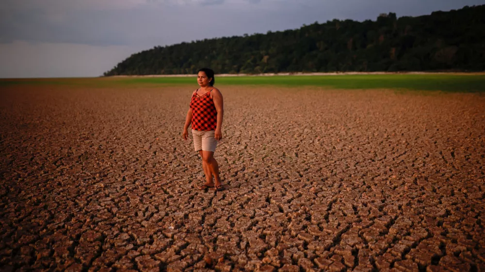 Alcineia de Sousa Ribeiro, 45, poses for a picture on the dry bed of a Tapajos river during the intense drought that hits the Amazon, at Prainha 1 community in Tapajos National Forest, Para state, Brazil October 10, 2024. REUTERS/Amanda Perobelli  TPX IMAGES OF THE DAY