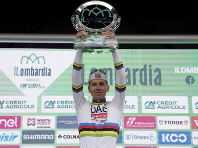 Reigning World Champion Slovenia's Tadej Pogacar celebrates on the podium after winning Il Lombardia, Tour of Lombardy cycling race, in Como, Italy, Saturday, Oct. 12, 2024. (Gian Mattia D'Alberto/LaPresse via AP)