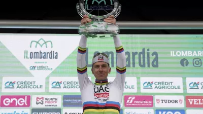 Reigning World Champion Slovenia's Tadej Pogacar celebrates on the podium after winning Il Lombardia, Tour of Lombardy cycling race, in Como, Italy, Saturday, Oct. 12, 2024. (Gian Mattia D'Alberto/LaPresse via AP)