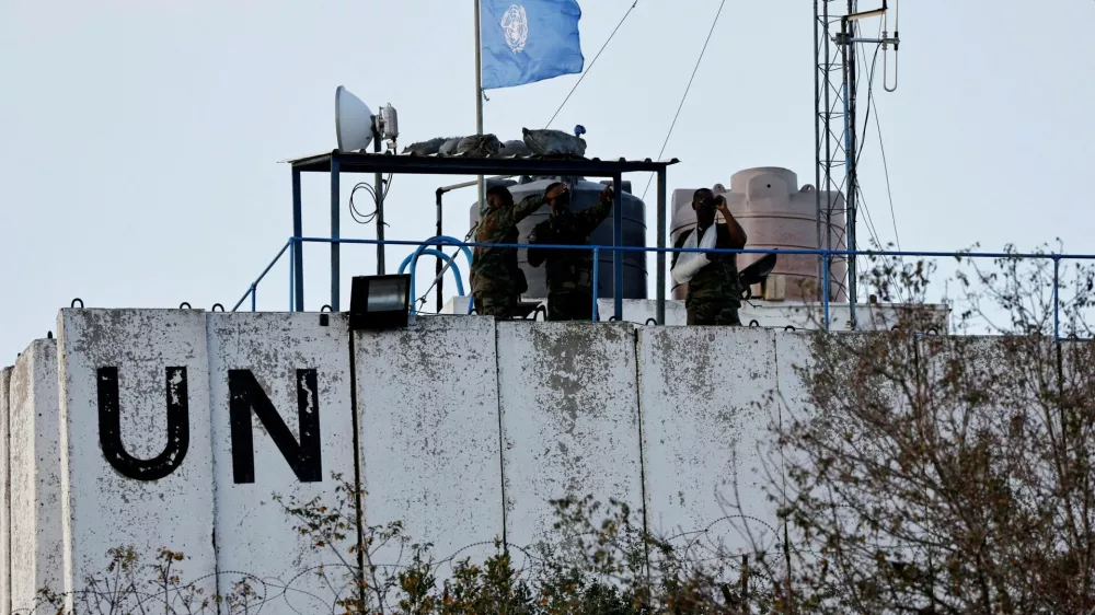 FILE PHOTO: Members of the United Nations peacekeepers (UNIFIL) look at the Lebanese-Israeli border, as they stand on the roof of a watch tower ‏in the town of Marwahin, in southern Lebanon, October 12, 2023. REUTERS/Thaier Al-Sudani/File Photo