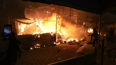 Palestinians try to extinguish fire caused by an Israeli strike that hit a tent area in the courtyard of Al Aqsa Martyrs hospital in Deir al-Balah, Gaza Strip, Monday, Oct. 14, 2024. (AP Photo/Abdel Kareem Hana)