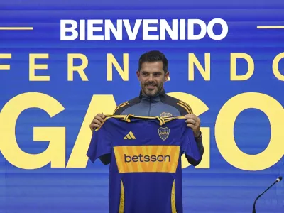 Fernando Gago poses for photos with a Boca Juniors jersey during his media presentation as the soccer team's new coach, in Buenos Aires, Argentina, Monday, Oct. 14, 2024. (AP Photo/Gustavo Garello)