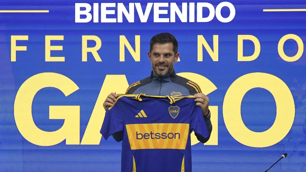 Fernando Gago poses for photos with a Boca Juniors jersey during his media presentation as the soccer team's new coach, in Buenos Aires, Argentina, Monday, Oct. 14, 2024. (AP Photo/Gustavo Garello)