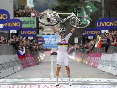 Reigning World Champion Slovenia's Tadej Pogacar holds up his bike as he celebrates winning Il Lombardia, Tour of Lombardy cycling race, in Como, Italy, Saturday, Oct. 12, 2024. (Gian Mattia D'Alberto/LaPresse via AP)