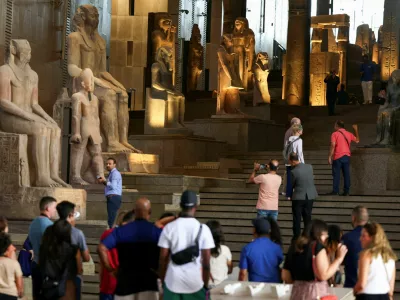 Tourists look at Pharaonic statues displayed at the Grand Staircase of the Grand Egyptian Museum during a partial trial in Giza, Egypt, October 15, 2024. REUTERS/Mohamed Abd El Ghany