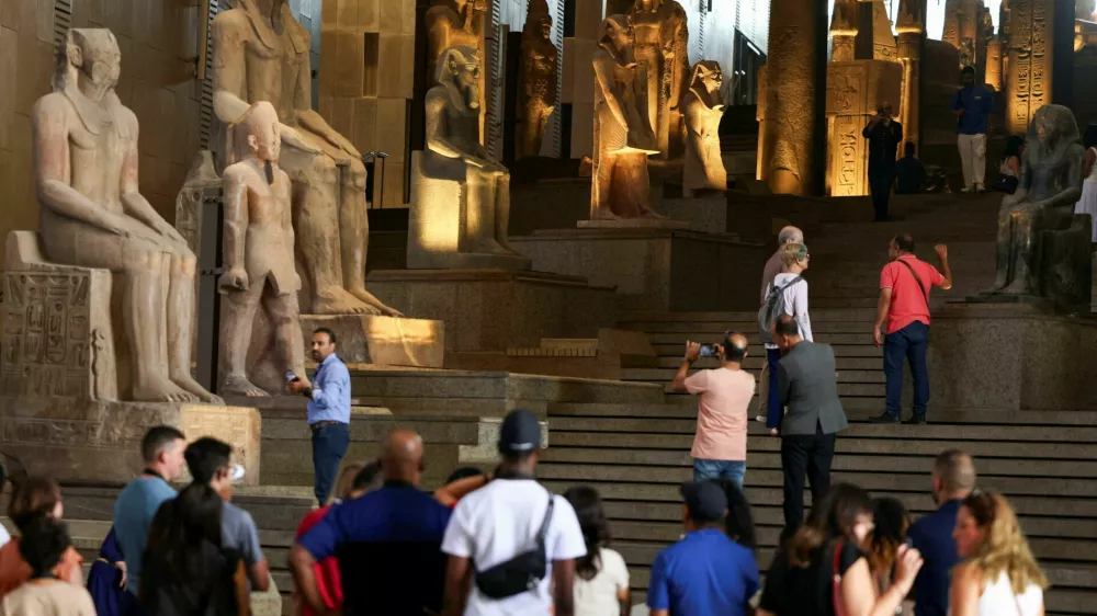 Tourists look at Pharaonic statues displayed at the Grand Staircase of the Grand Egyptian Museum during a partial trial in Giza, Egypt, October 15, 2024. REUTERS/Mohamed Abd El Ghany