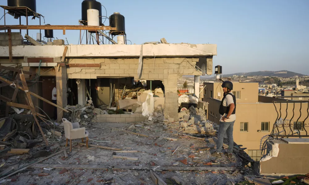 Israeli security forces survey damage to a home struck by a rocket fired from Lebanon in the town of Majd al-Krum, northern Israel, Wednesday, Oct. 16, 2024. (AP Photo/Ariel Schalit)