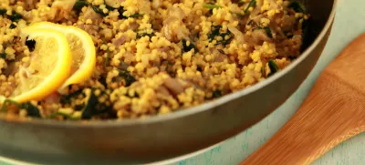 Vegetarian couscous with mushrooms and spinach. Vegan dish with millet in the frying pan. Close up. / Foto: Lora-sutyagina