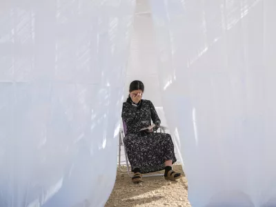 A Jewish woman prays in a sukkah, a small temporary hut constructed for the Jewish holiday of Sukkot, as part of a demonstration calling for Jewish resettlement of the Gaza Strip, near the Israeli-Gaza border, southern Israel, Monday, Oct. 21, 2024. (AP Photo/Tsafrir Abayov)