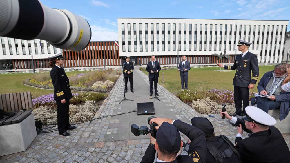 21 October 2024, Mecklenburg-Western Pomerania, Rostock: Boris Pistorius (C), Germany's Defence Minister, speaks to journalists after the installation ceremony for the Commander Task Force Baltic (CTF Baltic) in Rostock, with the Marine Operation Center MOC, headquarters of the new facility, in the background. Photo: Bernd Wüstneck/dpa