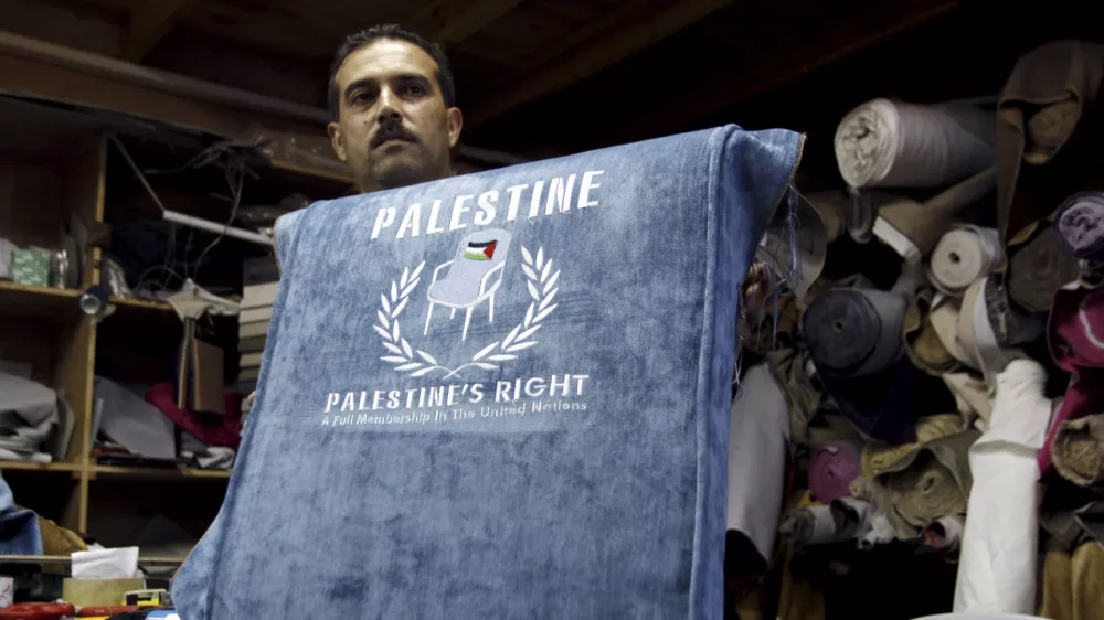 FILE - In this Sunday Aug. 28, 2011 file photo, a Palestinian worker shows a chair covered with embroidered blue upholstery featuring a Palestinian flag and the text: "Palestine, Palestine's Right. A Full Membership in the United Nations", at a workshop in the West Bank city of Jenin. The Palestinians are resigned to defeat in their quest for full membership at the United Nations, officials said Wednesday, Nov. 9, 2011, and have already started work on their backup plan: seeking an upgraded observer status that would give them access to key international organizations. (AP Photo/Mohammed Ballas, File)