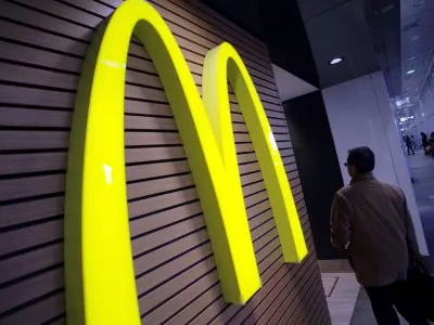 ﻿FILE - In this Dec. 17, 2014 file photo, a man walks by a McDonald's logo in front of its restaurant in Tokyo. McDonald's is set to unveil its latest plans to revive its sputtering business on Monday, May 4, 2015. (AP Photo/Eugene Hoshiko, File)