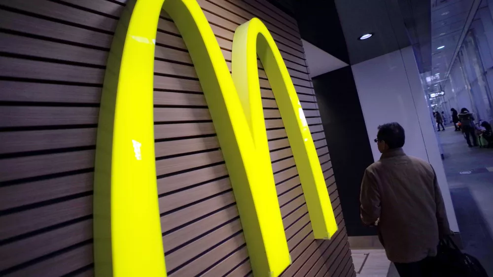 ﻿FILE - In this Dec. 17, 2014 file photo, a man walks by a McDonald's logo in front of its restaurant in Tokyo. McDonald's is set to unveil its latest plans to revive its sputtering business on Monday, May 4, 2015. (AP Photo/Eugene Hoshiko, File)