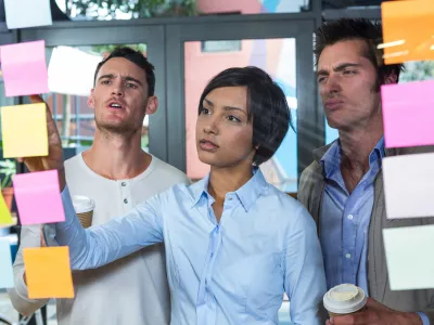 Colleagues looking at sticky notes in office / Foto: Wavebreakmedia