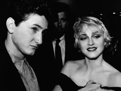 Actor Sean Penn and his wife, singer Madonna, stop to chat with reporters prior to the screening of Penn's new movie "At Close Range" in Los Angeles Thursday night, April 17, 1986. (AP Photo/Craig Mathew)