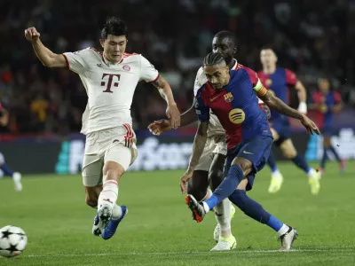 Barcelona's Raphinha, right, scores his sides forth goal as Bayern's Kim Min-jae, left, tries to stop him during a Champions League opening phase soccer match between Barcelona and Bayern Munich at the Lluis Companys Olympic Stadium in Barcelona, Spain, Wednesday, Oct. 23, 2024. (AP Photo/Joan Monfort)