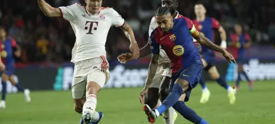 Barcelona's Raphinha, right, scores his sides forth goal as Bayern's Kim Min-jae, left, tries to stop him during a Champions League opening phase soccer match between Barcelona and Bayern Munich at the Lluis Companys Olympic Stadium in Barcelona, Spain, Wednesday, Oct. 23, 2024. (AP Photo/Joan Monfort)