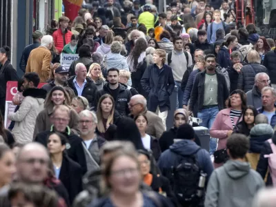 People walk along a shopping street in Dortmund, Germany, Thursday, Oct. 24, 2024. (AP Photo/Martin Meissner)