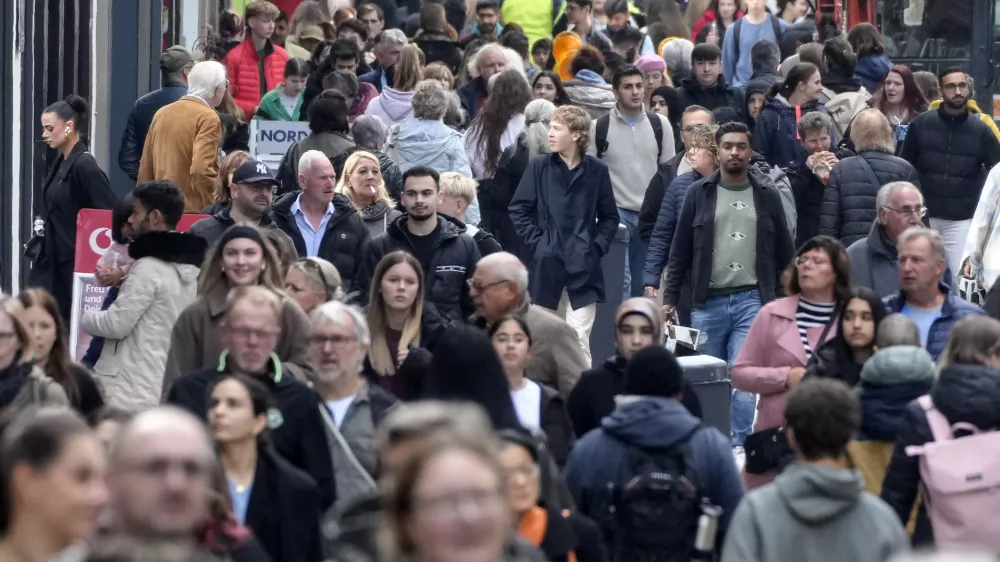 People walk along a shopping street in Dortmund, Germany, Thursday, Oct. 24, 2024. (AP Photo/Martin Meissner)