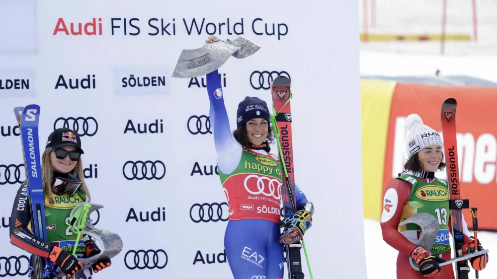 Alpine Skiing - FIS Alpine Ski World Cup - Women's Giant Slalom - Soelden, Austria - October 26, 2024 Italy's Federica Brignone celebrates with the trophy on the podium after winning the Women's Giant Slalom along with second placed New Zealand's Alice Robinson and third placed Austria's Julia Scheib REUTERS/Leonhard Foeger