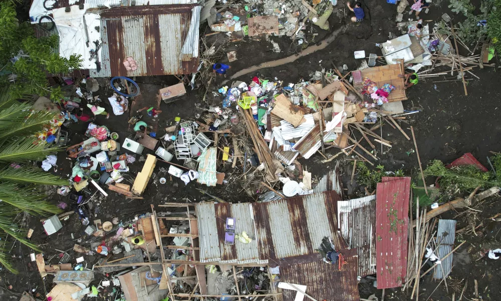 Residents gather what they can from their damaged homes on Saturday, Oct. 26, 2024 after being struck by a landslide triggered by Tropical Storm Trami in Talisay, Batangas province, Philippines. (AP Photo/Aaron Favila)