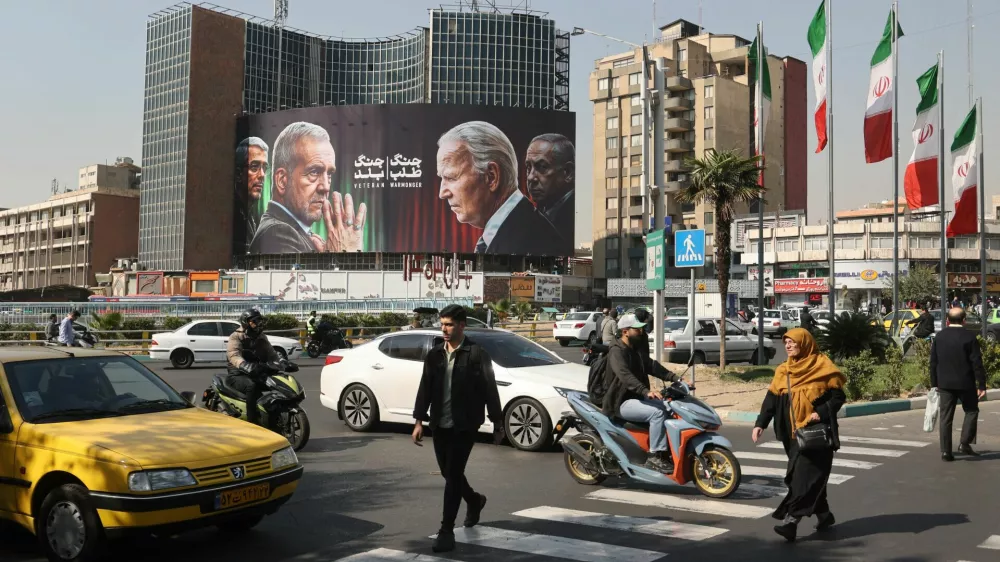 Iranians walk next to an anti-U.S. and Israeli billboard with pictures of Iranian President Masoud Pezeshkian and Iranian Armed Forces Chief of Staff, Major General Mohammad Bagheri and U.S. President Joe Biden and Israel's Prime Minister Benjamin Netanyahu, on a street in Tehran, Iran, October 27, 2024. Majid Asgaripour/WANA (West Asia News Agency) via REUTERS ATTENTION EDITORS - THIS IMAGE HAS BEEN SUPPLIED BY A THIRD PARTY  ATTENTION EDITORS - THIS PICTURE WAS PROVIDED BY A THIRD PARTY