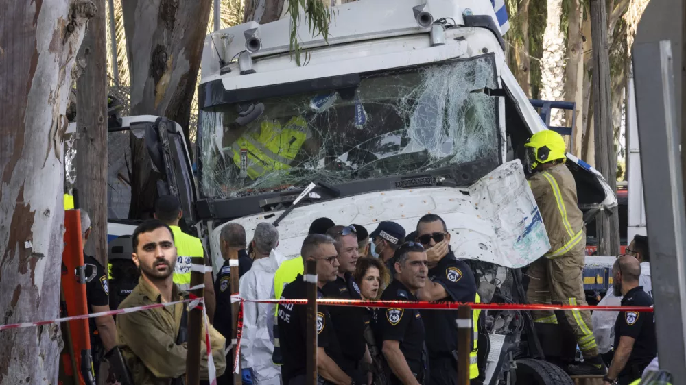 Israeli police and rescue services inspect the site where a truck driver rammed into a bus stop near an army base, wounding dozens of people, according to Israel's Magen David Adom rescue service in Ramat Hasharon, Israel, Sunday, Oct. 27, 2024. (AP Photo/Oded Balilty)