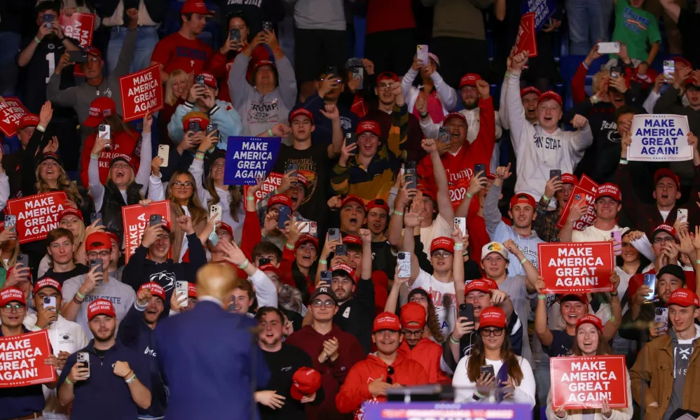 Attendees interact with Republican presidential nominee and former U.S. President Donald Trump at a campaign event, in State College, Pennsylvania, U.S., October 26, 2024. REUTERS/Hannah McKay