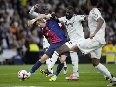 Barcelona's Robert Lewandowski fights for the ball during a Spanish La Liga soccer match between Real Madrid and Barcelona at the Santiago Bernabeu stadium in Madrid, Spain, Saturday, Oct. 26, 2024. (AP Photo/Bernat Armangue)