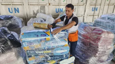 FILE - United Nations and Red Crescent workers prepare the aid for distribution to Palestinians at UNRWA warehouse in Deir Al-Balah, Gaza Strip, on Monday, Oct. 23, 2023. (AP Photo/Hassan Eslaiah, File)