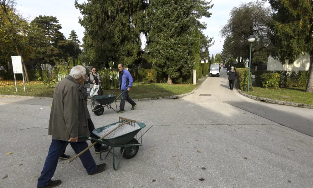 V ponedeljek so ljudje poskrbeli še za zadnje lepotne popravke na grobovih. Foto: Luka Cjuha