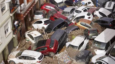 Residents look at cars piled up after being swept away by floods in Valencia, Spain, Wednesday, Oct. 30, 2024. (AP Photo/Alberto Saiz)