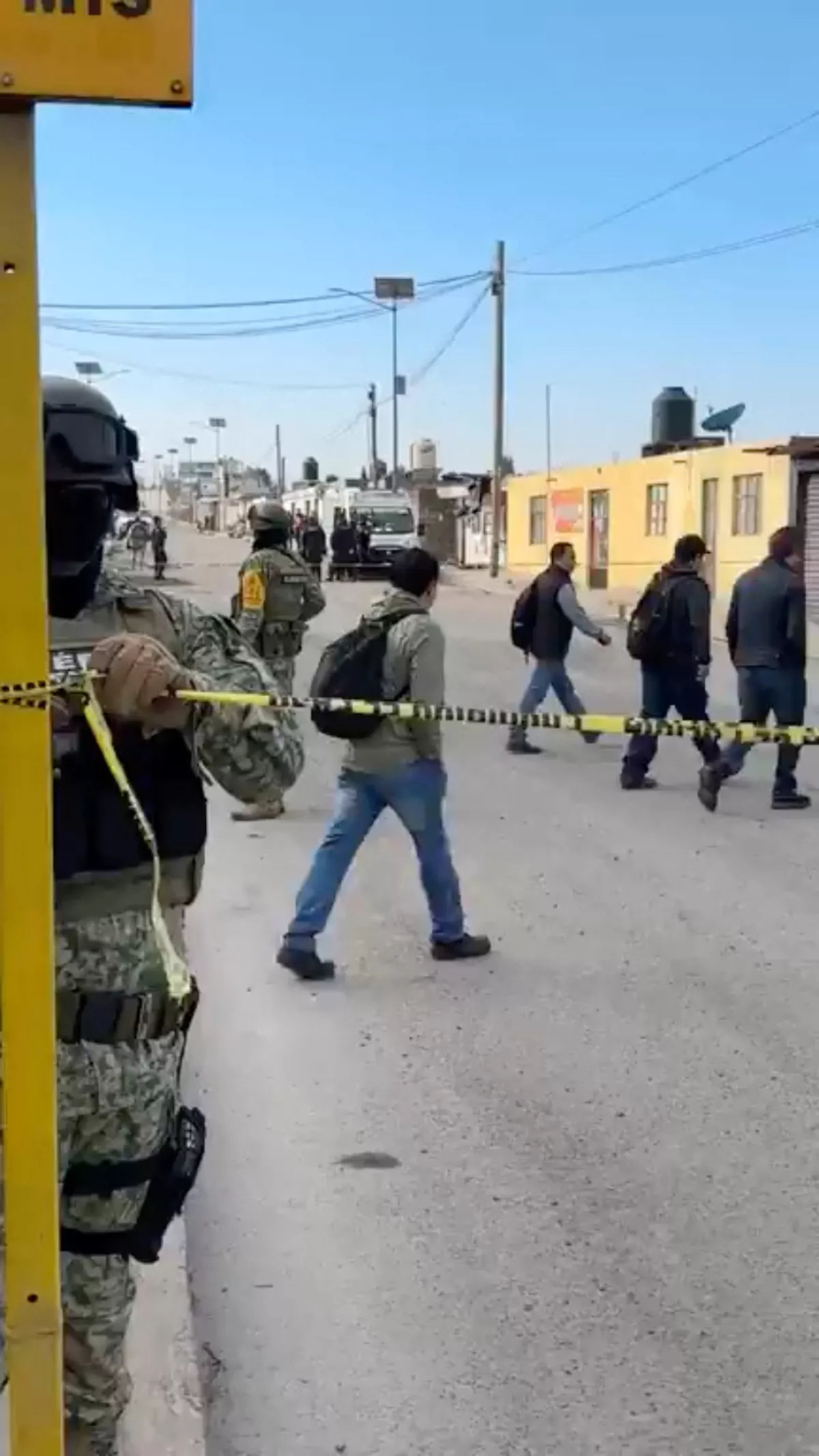 People cross the street near a member of the Mexican Army, with an ambulance in the background, after an explosion at a Simec-owned steel plant in Mexico's central Tlaxcala state, at San Cosme Xaloztoc, Tlaxcala state, Mexico, October 30, 2024, in this screengrab from a handout video. PRENSA DE TLAXCALA/Handout via REUTERS. THIS IMAGE HAS BEEN SUPPLIED BY A THIRD PARTY.NO RESALES. NO ARCHIVES. MANDATORY CREDIT