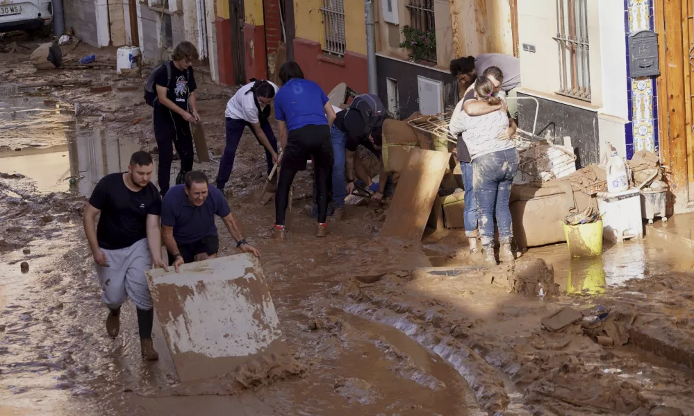 Residents clean their houses affected by floods in Valencia, Spain, Thursday, Oct. 31, 2024. (AP Photo/Alberto Saiz)