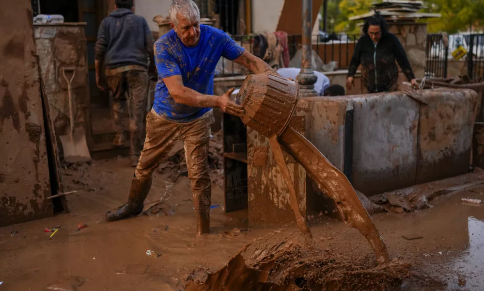 A man cleans his house affected by floods in Utiel, Spain, Wednesday, Oct. 30, 2024. (AP Photo/Manu Fernandez)