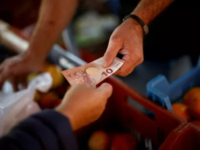 FILE PHOTO: A shopper pays with a ten Euro bank note at a local market in Nantes, France, September 17, 2024. REUTERS/Stephane Mahe/File Photo