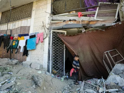 A displaced Palestinian boy stands outside a damaged store where he shelters with his family who fled northern Gaza due to an Israeli military operation, shelter in a school in Gaza City, October 28, 2024. REUTERS/Dawoud Abu Alkas