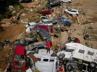 A man stands among flooded cars piled up in Valencia, Spain, Thursday, Oct. 31, 2024. (AP Photo/Manu Fernandez)