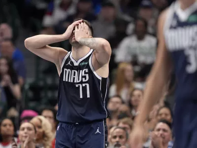 Dallas Mavericks guard Luka Doncic (77) covers his face with his hands taking a shot in the first half of an NBA basketball game against the Houston Rockets in Dallas, Thursday, Oct. 31, 2024. (AP Photo/Tony Gutierrez)