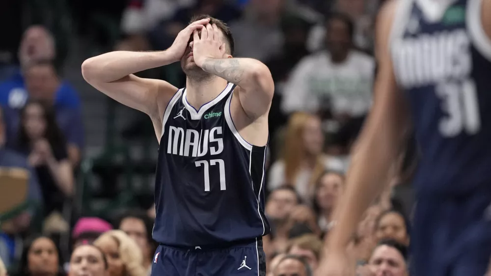 Dallas Mavericks guard Luka Doncic (77) covers his face with his hands taking a shot in the first half of an NBA basketball game against the Houston Rockets in Dallas, Thursday, Oct. 31, 2024. (AP Photo/Tony Gutierrez)