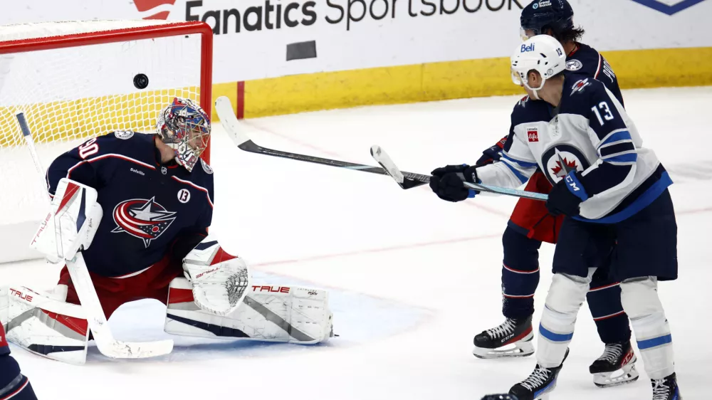 Winnipeg Jets forward Gabriel Vilardi, right, watches teammate defenseman Josh Morrissey's goal past Columbus Blue Jackets goalie Elvis Merzlikins, left, and defenseman Ivan Provorov during the third period of an NHL hockey game in Columbus, Ohio, Friday, Nov. 1, 2024. The Jets won 6-2. (AP Photo/Paul Vernon)