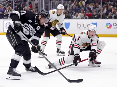 Los Angeles Kings center Anze Kopitar, left, controls the puck against Chicago Blackhawks defenseman Connor Murphy during the second period of an NHL hockey game, Saturday, Nov. 2, 2024, in Los Angeles. (AP Photo/Ryan Sun)