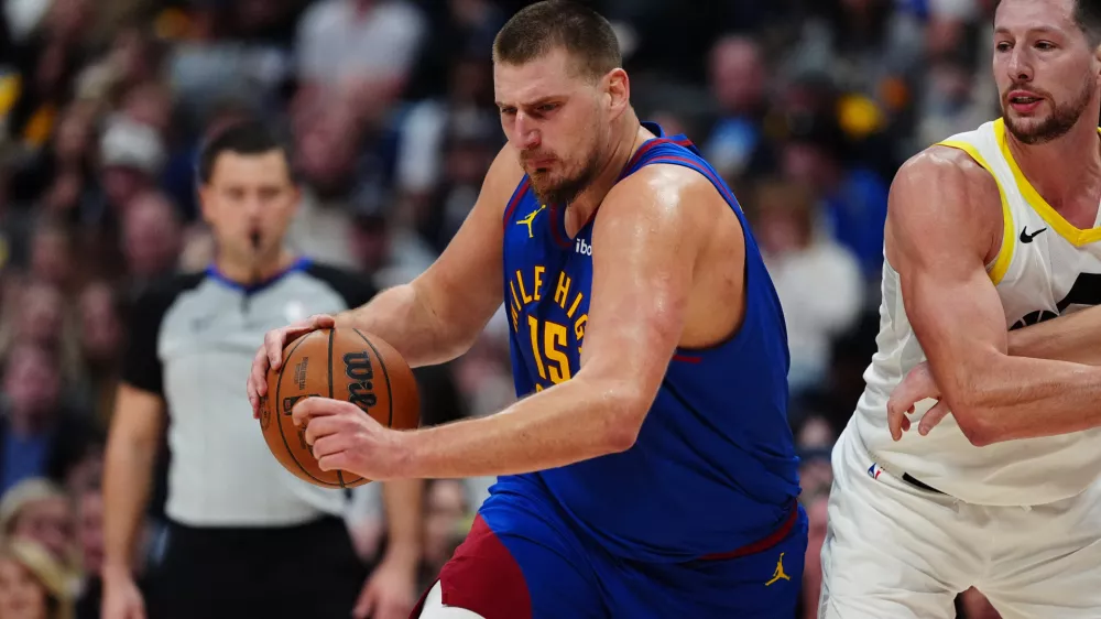 Nov 2, 2024; Denver, Colorado, USA; Denver Nuggets center Nikola Jokic (15) controls the ball past Utah Jazz forward Kyle Filipowski (22) in the second half at Ball Arena. Mandatory Credit: Ron Chenoy-Imagn Images