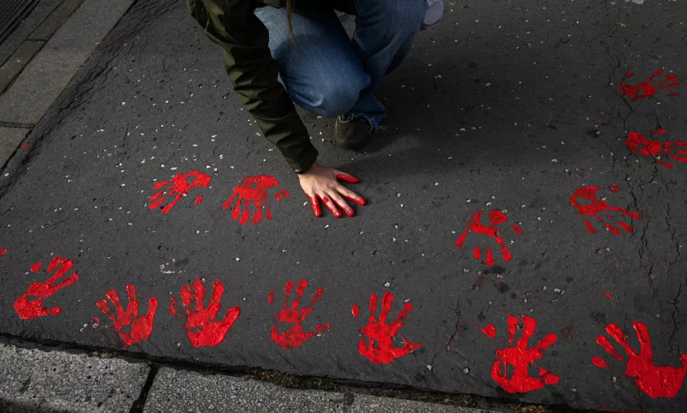 Demonstrators leave red hand prints on a sidewalk as they protest to commemorate an accident at a railway station in the Serbian city of Novi Sad, for which they blame negligence and corruption by the authorities, in front of the government in Belgrade, Serbia November 3, 2024. REUTERS/Marko Djurica